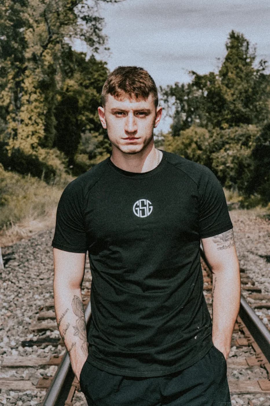 The Pilot black gym tee worn on the railroad tracks